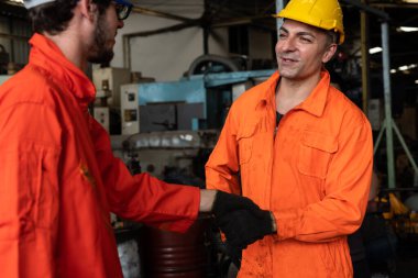 Takım çalışması ve ortaklık gösteren iki yetenekli fabrika mühendisi ya da işçi .