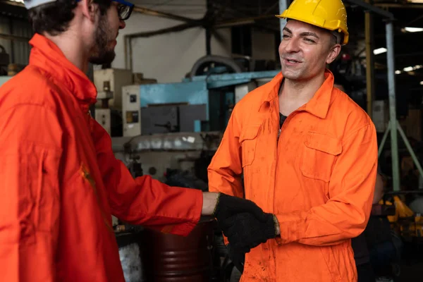 Dos hábiles ingenieros de fábrica o trabajadores que muestran trabajo en equipo y asociación . — Foto de Stock