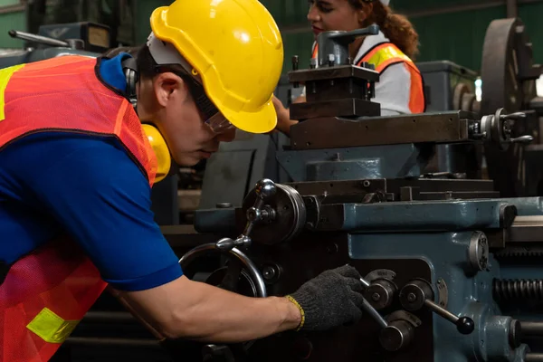 Groupe de travailleurs habiles utilisant des équipements de machine dans l'atelier d'usine — Photo