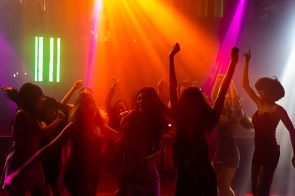 Silhouet beeld van mensen dansen in disco nachtclub op muziek van DJ op het podium — Stockfoto