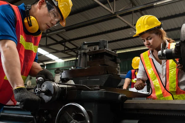 在工厂车间使用机械设备的技术工人小组 — 图库照片