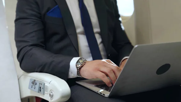Jovem empresário usando computador portátil no avião — Fotografia de Stock