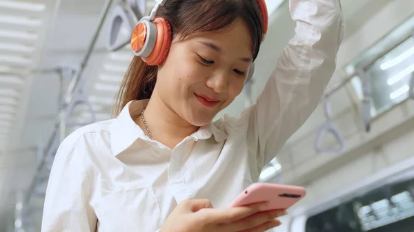 Jeune femme utilisant un téléphone portable dans le train public — Photo