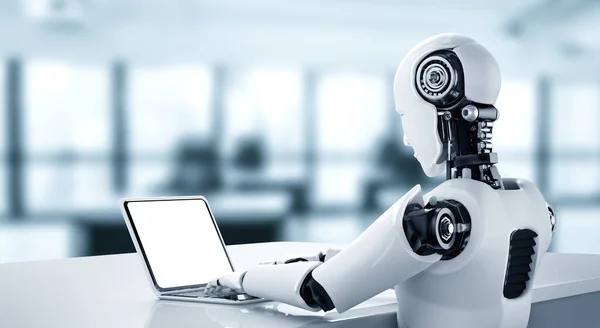 Robô humanóide usar laptop e sentar-se à mesa no futuro escritório — Fotografia de Stock
