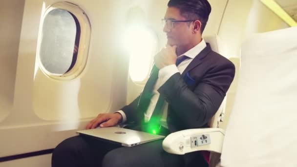 Jonge zakenman met laptop in het vliegtuig — Stockvideo