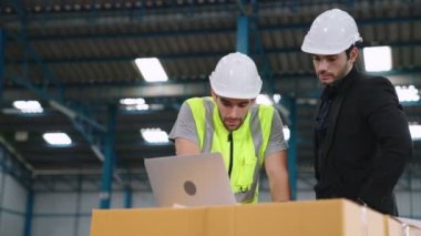 Fabrikada çalışan ve üretim planını tartışan iki fabrika işçisi. .