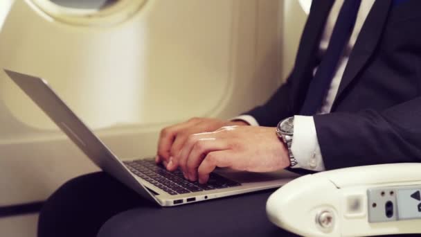Mladý podnikatel pomocí notebooku v letadle