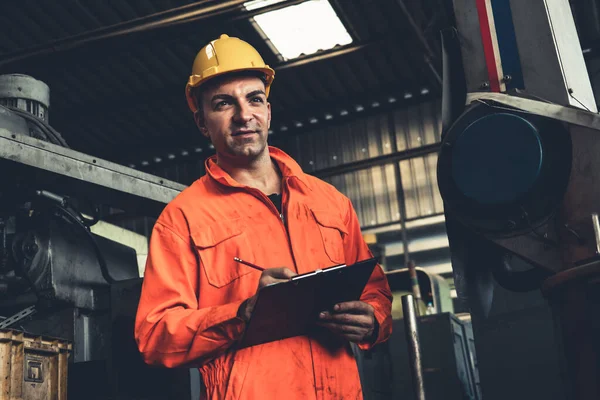 Kompetent fabriksarbetare som arbetar med urklipp för att göra jobbet förfarande checklista . — Stockfoto