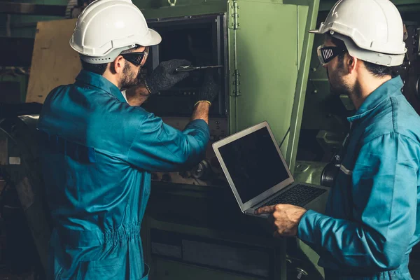 Grupo de trabalhadores de fábrica habilidosos usando equipamentos de máquinas em oficina — Fotografia de Stock