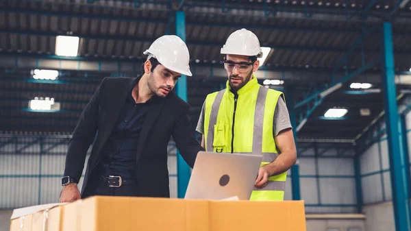 Fabrikada çalışan ve üretim planını tartışan iki fabrika işçisi. . — Stok fotoğraf