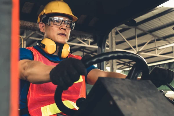 Un travailleur habile conduit un chariot élévateur à fourche dans l'usine . — Photo