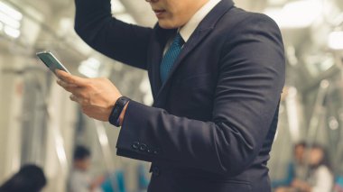 İş adamı trende cep telefonu kullanıyor.