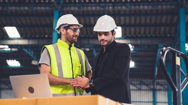 Två fabriksarbetare arbetar och diskuterar tillverkningsplan i fabriken . — Stockfoto