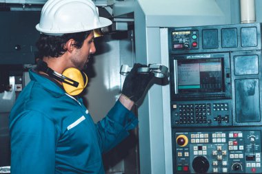 Akıllı fabrika işçisi veya mühendisi imalat atölyesinde makine işi yapıyor.