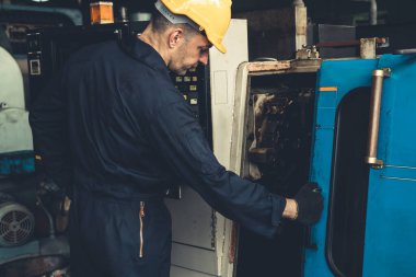 Fabrika mühendisi veya işçisi üretim atölyesinde makine işi yapıyor.