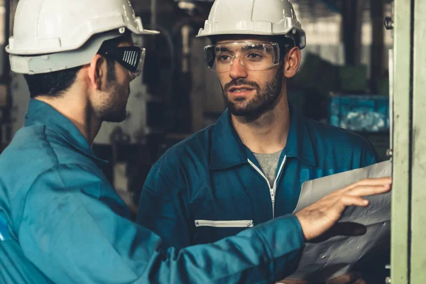 Grupo de trabalhadores de fábrica habilidosos usando equipamentos de máquinas em oficina — Fotografia de Stock