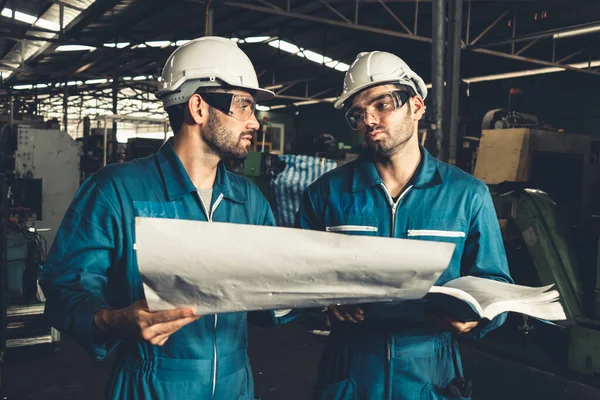 Grupo de trabalhadores de fábrica habilidosos usando equipamentos de máquinas em oficina — Fotografia de Stock