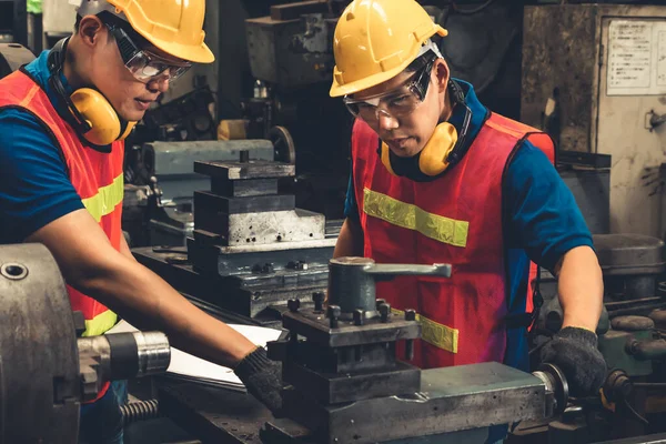 Grupo de trabalhadores de fábrica habilidosos usando equipamentos de máquinas em oficina — Fotografia de Stock