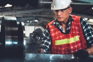 Akıllı fabrika işçisi veya mühendisi bir imalat atölyesinde makine işi yapıyor.