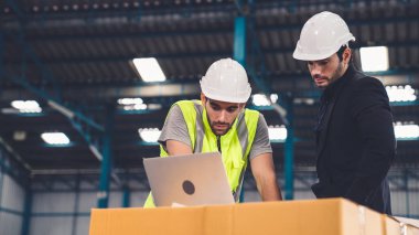 Fabrikada çalışan ve üretim planını tartışan iki fabrika işçisi. .
