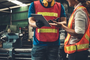 Tablet bilgisayarda projeyi tartışan iki yetenekli fabrika mühendisi veya işçi