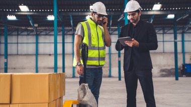 Fabrikada çalışan ve üretim planını tartışan iki fabrika işçisi. .