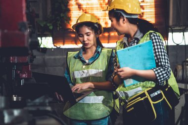 Fabrika işçileri fabrikada çalışıyor ve üretim planlarını tartışıyorlar.