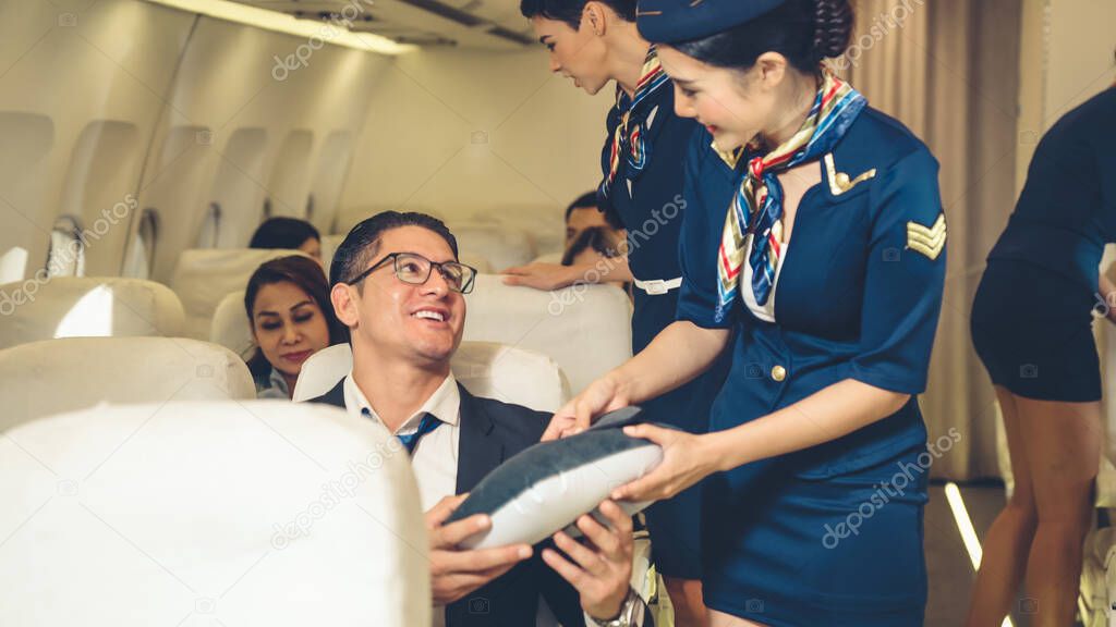 Cabin crew give service to passenger in airplane