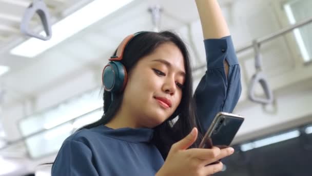 Jonge vrouw met mobiele telefoon op de openbare trein — Stockvideo