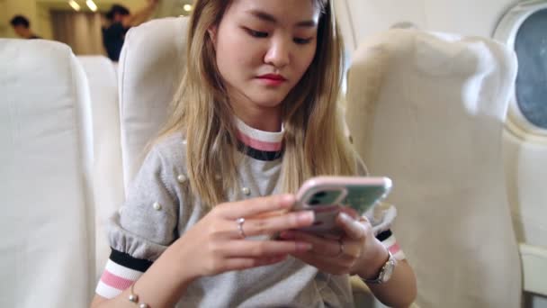 Mulher asiática usando telefone celular no avião — Vídeo de Stock