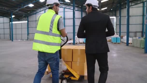 Trabajadores de la fábrica entregan paquetes de cajas en un carro de empuje en el almacén . — Vídeos de Stock