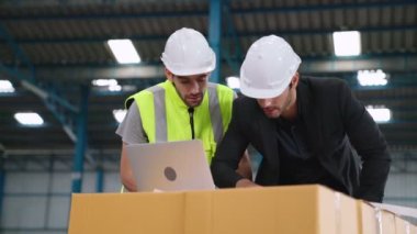 Fabrikada çalışan ve üretim planını tartışan iki fabrika işçisi. .