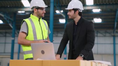 Fabrikada çalışan ve üretim planını tartışan iki fabrika işçisi. .