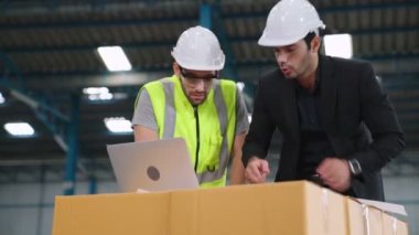Fabrikada çalışan ve üretim planını tartışan iki fabrika işçisi. .