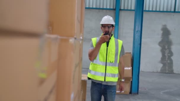 Trabajador de carga profesional habla por radio portátil para contactar a otro trabajador — Vídeo de stock