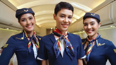 Bir grup kabin görevlisi ya da hostes uçakta.