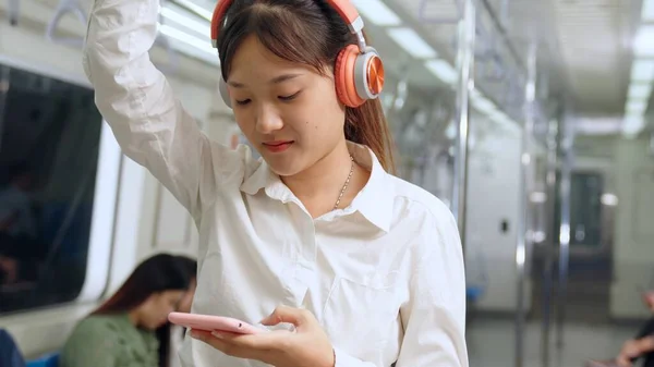 Jeune femme utilisant un téléphone portable dans le train public — Photo