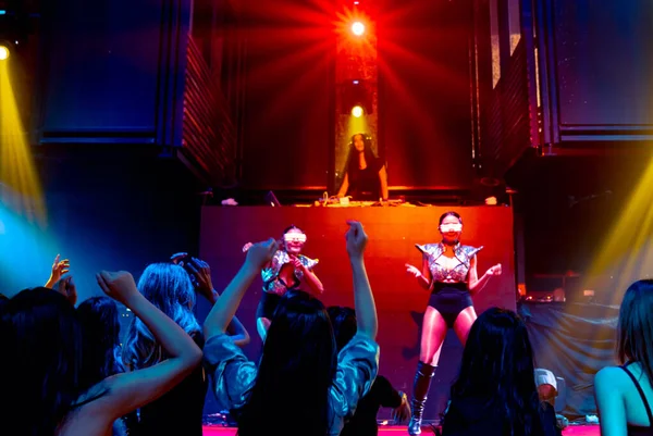 Egy csapat ember táncol a disco night clubban DJ zenéjére a színpadon. — Stock Fotó