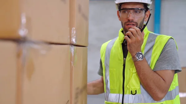 Trabalhador de carga profissional fala em rádio portátil para entrar em contato com outro trabalhador — Fotografia de Stock