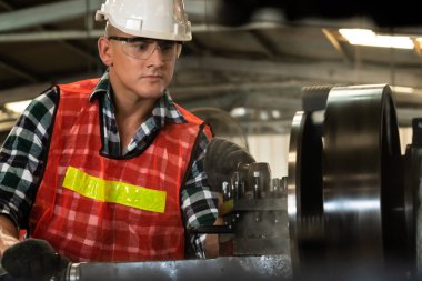 Akıllı fabrika işçisi veya mühendisi bir imalat atölyesinde makine işi yapıyor.