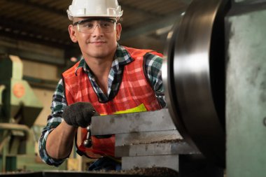 Akıllı fabrika işçisi veya mühendisi bir imalat atölyesinde makine işi yapıyor.