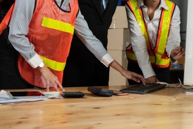 Depo müdürü ve işçisi depoda çalışıyor.