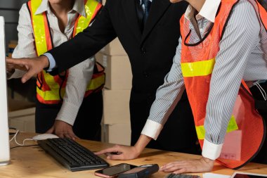 Depo müdürü ve işçisi depoda çalışıyor.