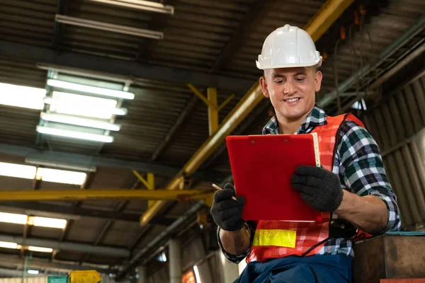 Trabajador de fabricación que trabaja con portapapeles para hacer la lista de verificación del procedimiento de trabajo . — Foto de Stock