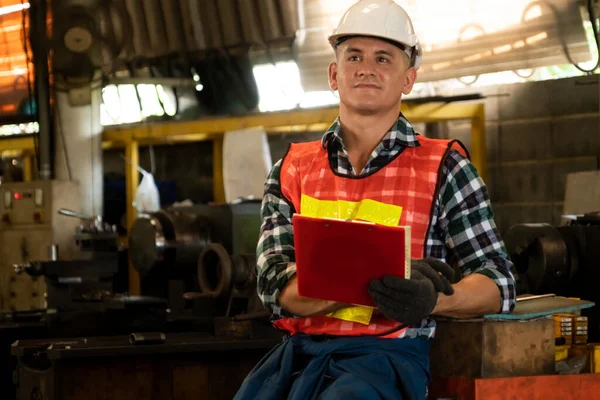 Trabajador de fabricación que trabaja con portapapeles para hacer la lista de verificación del procedimiento de trabajo . — Foto de Stock