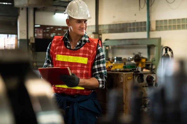 Trabajador de fabricación que trabaja con portapapeles para hacer la lista de verificación del procedimiento de trabajo . — Foto de Stock