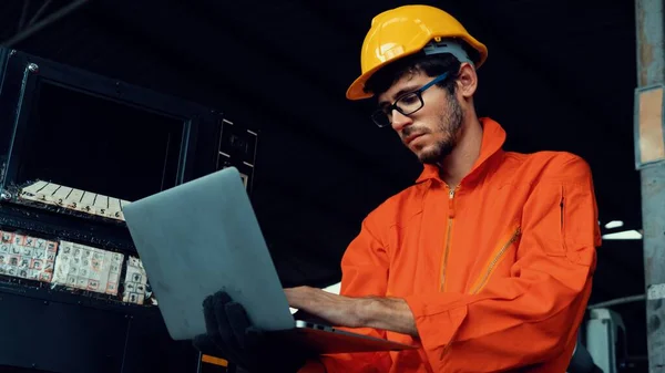 Trabalhador de fábrica hábil trabalhando com computador portátil para fazer a lista de verificação do procedimento . — Fotografia de Stock