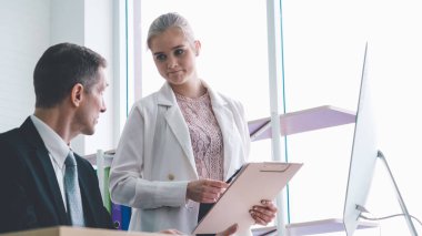 İki iş adamı ofiste proje stratejisi hakkında konuşuyor