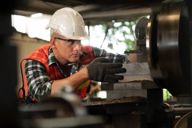 Akıllı fabrika işçisi veya mühendisi bir imalat atölyesinde makine işi yapıyor.
