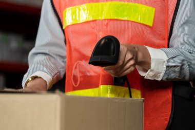 Depo çalışanı depoda barkod tarayıcısı kullanıyor.